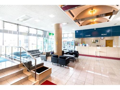 a lobby with a waiting area with chairs and tables at Hotel Yutaka Wing in Izumi-Sano