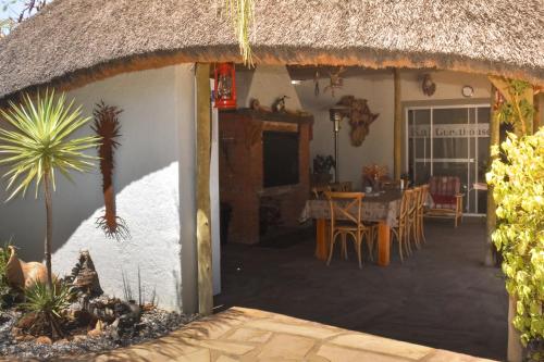an outside view of a house with a thatch roof at Kamaku Guesthouse cc in Otjiwarongo