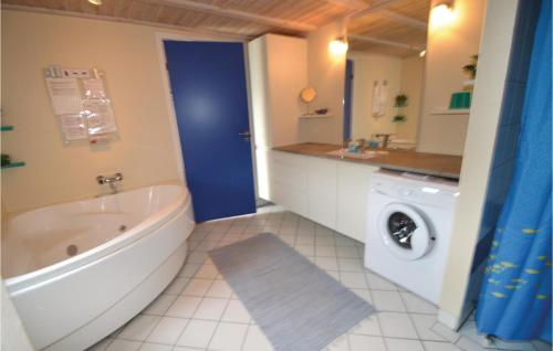 GrønhøjにあるNice Home In Lkken With 3 Bedrooms, Sauna And Wifiのバスルーム(バスタブ、洗濯機付)