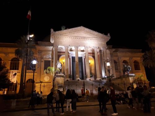 un edificio con gente de pie delante de él por la noche en THE VIEW, en Palermo