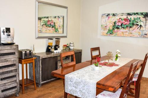 a dining room with a table and a kitchen at Kamaku Guesthouse cc in Otjiwarongo