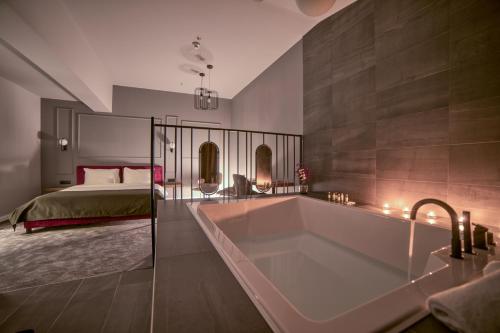 uma grande casa de banho com uma banheira e uma cama em Boscovich Boutique Hotel em Podgorica