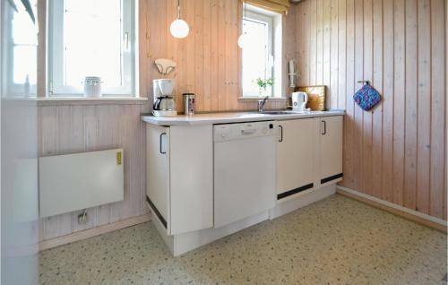Bjerregårdにある2 Bedroom Nice Home In Hvide Sandeの白いキャビネットとシンク付きのキッチン