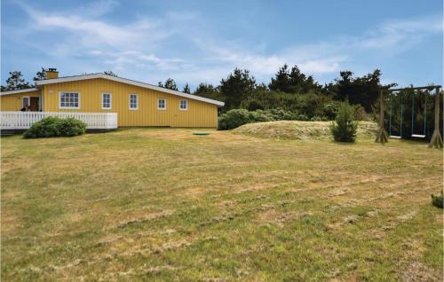 a yellow house with a large yard in front of it at Holiday Home Hvide Sande 48 in Bjerregård
