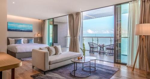 a bedroom with a bed and a living room at Prince Hotel Da Nang - Formerly Sel de Mer Hotel & Suites in Danang