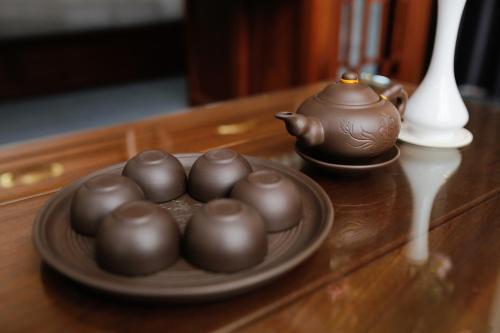 a plate of chocolate balls on a table with a tea pot at Bảo Hân Hotel in Ha Long