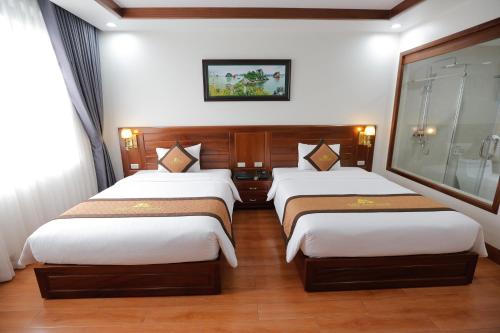 a hotel room with two beds in a room at Bảo Hân Hotel in Ha Long
