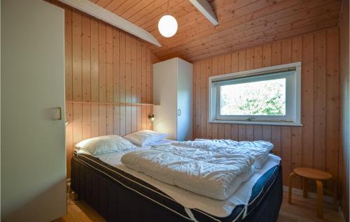 a bedroom with a large bed in a wooden wall at Holiday Home Kromosevej Rømø Denm in Rømø Kirkeby