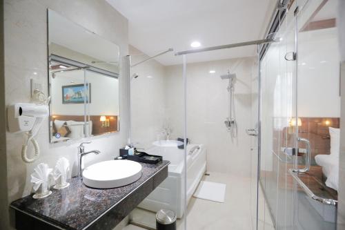 a white bathroom with a sink and a shower at Bảo Hân Hotel in Ha Long