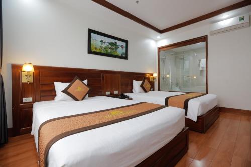 a hotel room with two beds and a window at Bảo Hân Hotel in Ha Long