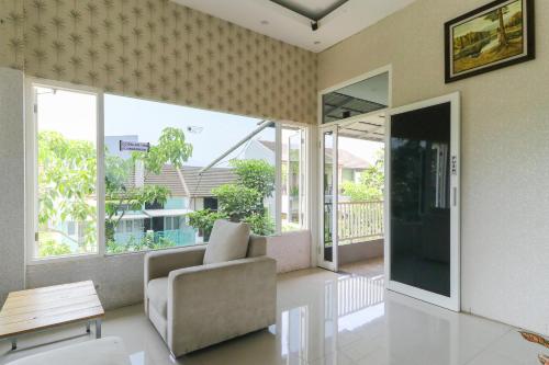 a living room with a chair and a table at Griya Mulya near Alun Alun Batu Mitra RedDoorz in Batu