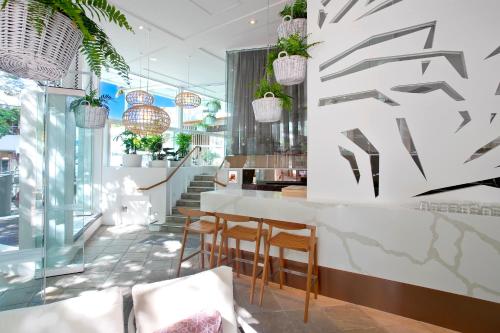 a restaurant with chairs and a counter with plants at Sofitel Noosa Pacific Resort in Noosa Heads