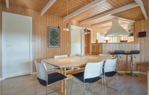 a dining room with a wooden table and chairs at Holiday Home Kromosevej Rømø Denm in Rømø Kirkeby