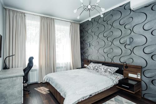 een slaapkamer met een bed en een muur met een patroon bij Квартира в центре для гурманов стиля in Chernihiv