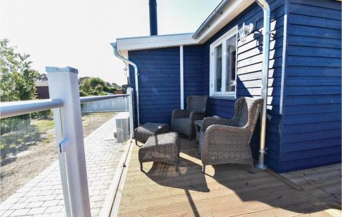 a porch with wicker chairs and a blue house at Three-Bedroom Holiday Home In Nyborg in Nyborg
