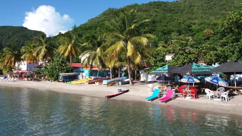 a beach with a group of tables and chairs at Turquoise Caritan in Sainte-Anne