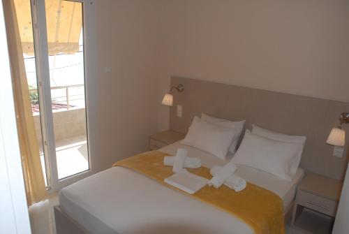 a bedroom with a bed with two towels on it at Eleni Kandilari Rooms in Kókkinon Nerón