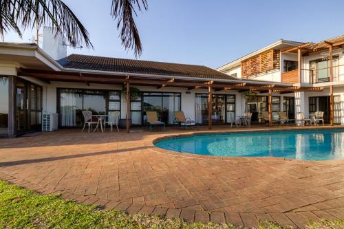 a swimming pool in front of a house at The Ridge Guesthouse in Richards Bay