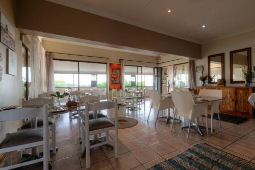 a dining room with tables and chairs in a restaurant at The Ridge Guesthouse in Richards Bay