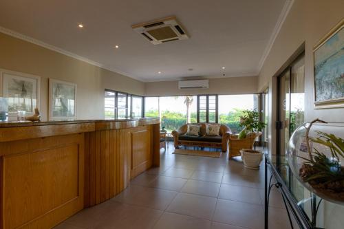 a lobby with a waiting area with a couch and windows at The Ridge Guesthouse in Richards Bay