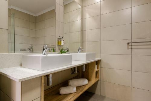 a bathroom with two sinks and a mirror at The Ridge Guesthouse in Richards Bay