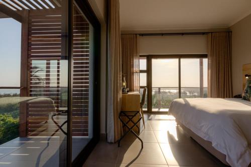 a bedroom with a bed and a large window at The Ridge Guesthouse in Richards Bay
