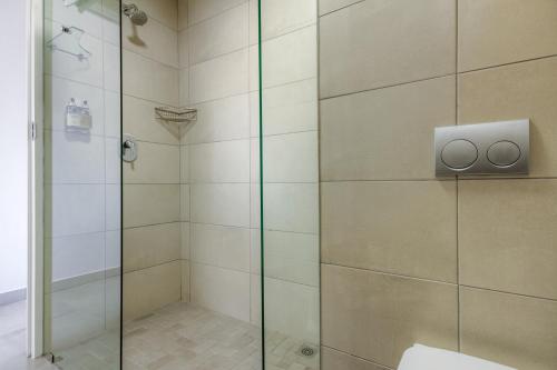 a bathroom with a shower with a glass door at The Ridge Guesthouse in Richards Bay