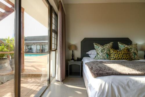 a bedroom with a bed and a view of a pool at The Ridge Guesthouse in Richards Bay