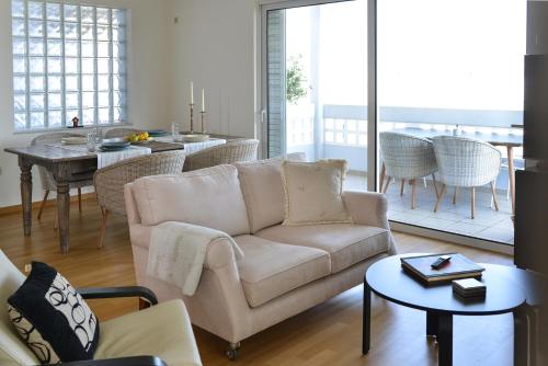 uma sala de estar com um sofá e uma mesa em Boutique Penthouse next to Stavros Niarchos Foundation em Atenas