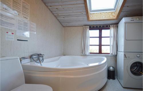 a bathroom with a white tub and a washing machine at Gimle in Bolilmark