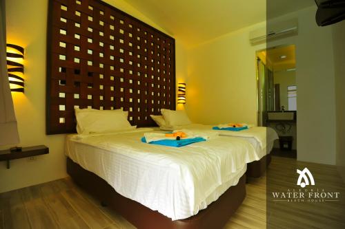 a bedroom with a large white bed with blue napkins on it at Alegria Water Front Beach House in Alegria