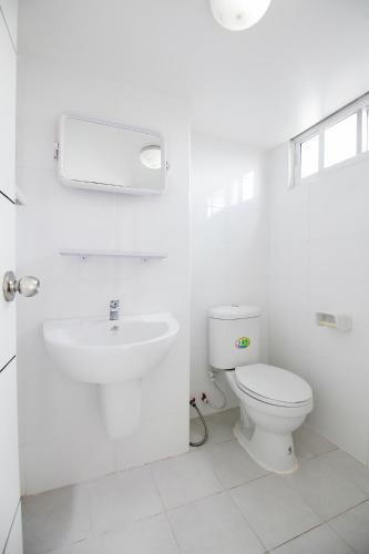 a white bathroom with a toilet and a sink at SLT Apartment Bangkok in Bangkok