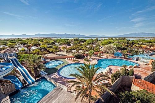 une vue aérienne d'un complexe avec deux piscines dans l'établissement Mobil home à 100 m des plages dans camping 4 étoiles avec vue sur la montagne, à Canet