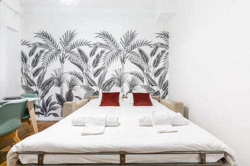 een slaapkamer met een bed met een muurschildering van palmbomen bij STRASBOURG HYPER CENTRE 2P de 30m2 in Straatsburg