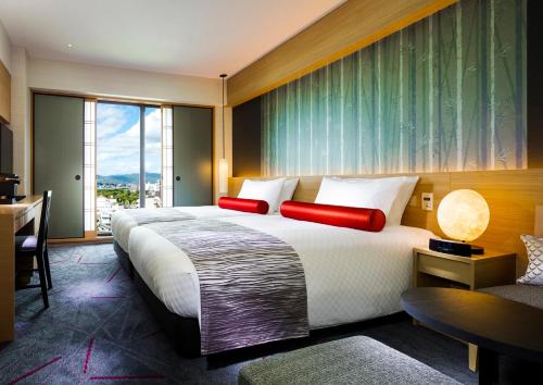 a hotel room with a large bed and a desk at RIHGA Royal Hotel Kyoto in Kyoto