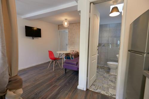 a room with a table and a bathroom with a toilet at Stanford apartments in Bucharest