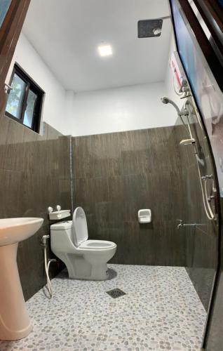 a bathroom with a toilet and a sink at Kobe's Beachfront Haven in Siquijor