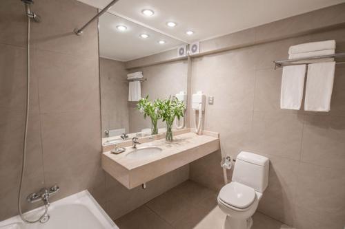 a bathroom with a sink and a toilet and a mirror at Hotel RP in Temuco