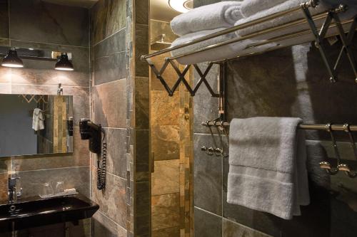 y baño con ducha, lavabo y toallas. en Hôtel E Tre Stelle, en Bonifacio