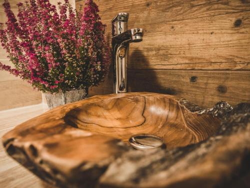 a wooden sink with a faucet and a vase of flowers at Dom Tatrzański Ewa Deluxe in Kościelisko
