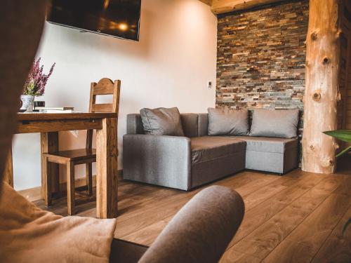 a living room with a couch and a brick wall at Dom Tatrzański Ewa Deluxe in Kościelisko