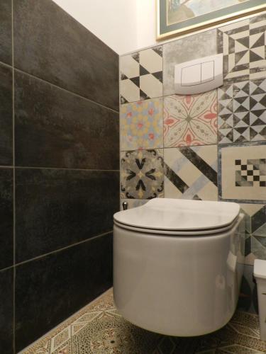 a bathroom with a toilet and a tile wall at Klassik and sunny Apartment! in Vienna