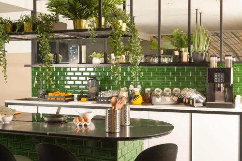 a kitchen with green subway tiles and a table at Aparthotel Adagio Brussels Grand Place in Brussels
