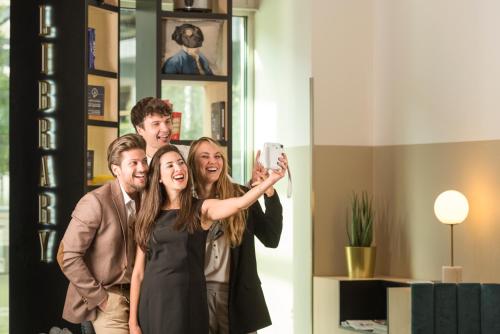 a group of people taking a picture with a cell phone at Aparthotel Adagio Brussels Grand Place in Brussels