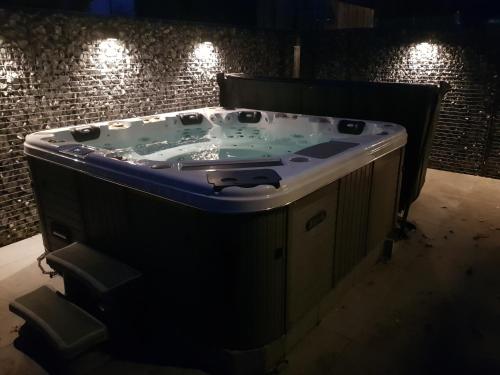 a jacuzzi tub in a room with a brick wall at Hier begint den hemel. in Beffe