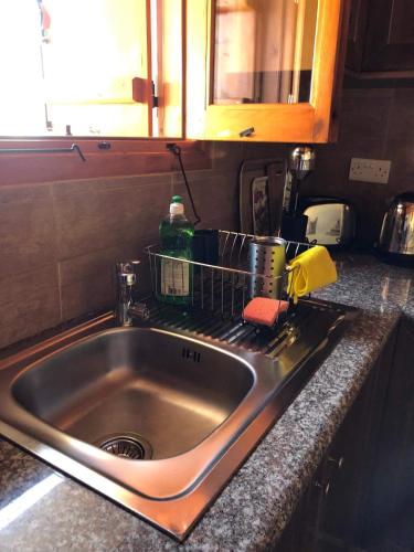 a kitchen sink with a dish drying rack next to it at Fontana Traditional House in Anarita