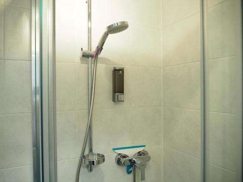 a shower with a shower head in a bathroom at Bungalow Apartment FREE Parking & Self Check-in in Graz