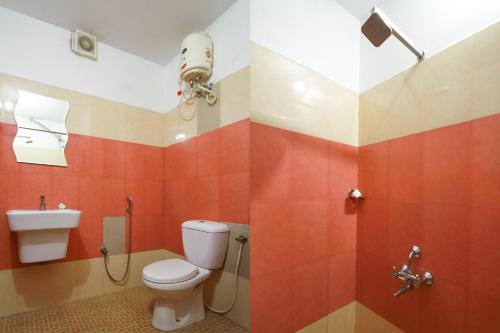 a bathroom with a toilet and a shower stall at Half Moon Residency Calicut in Kozhikode