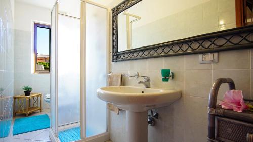 uma casa de banho com um lavatório e um espelho em Carlo Felice em Santa Teresa Gallura