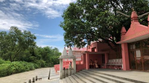 a pink building with people standing outside of it at Amrit Bhawan in Haridwār